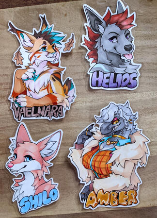 A photo of four cut and laminated badges done in marker. A photo of four cut and laminated badges done in marker.